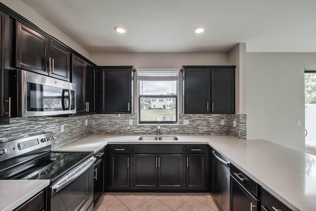 kitchen featuring light tile patterned floors, stainless steel appliances, sink, and decorative backsplash