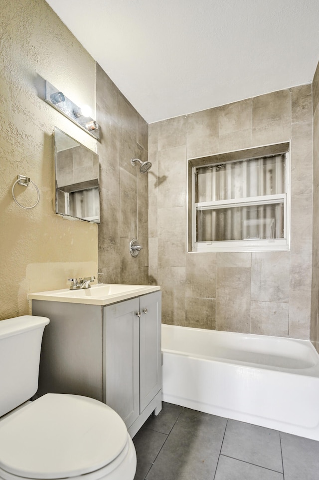 full bathroom featuring tile patterned floors, vanity, toilet, and tiled shower / bath