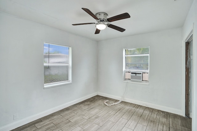 empty room featuring plenty of natural light, ceiling fan, light wood-type flooring, and cooling unit