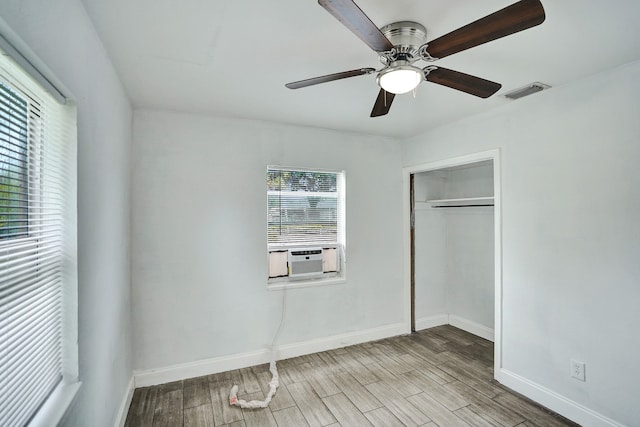 unfurnished bedroom with ceiling fan, a closet, cooling unit, and light wood-type flooring