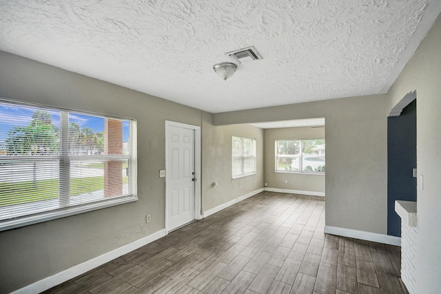 spare room with hardwood / wood-style flooring and a textured ceiling