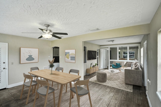 dining room featuring a textured ceiling, ceiling fan, and dark wood-type flooring