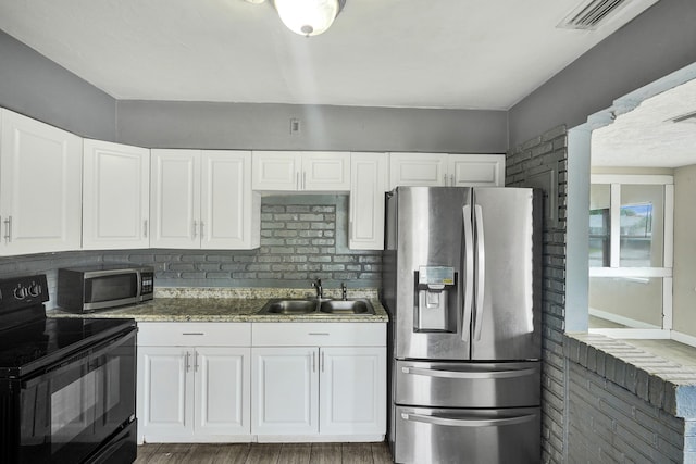 kitchen featuring appliances with stainless steel finishes, dark hardwood / wood-style flooring, backsplash, sink, and white cabinets