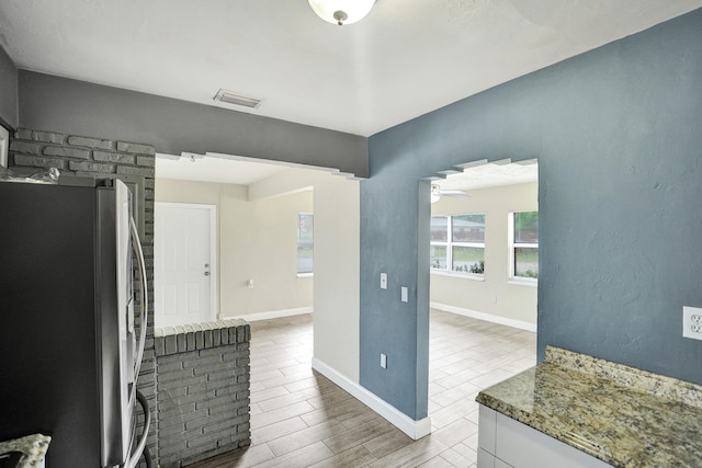 kitchen with stainless steel fridge, light hardwood / wood-style floors, white cabinetry, and ceiling fan