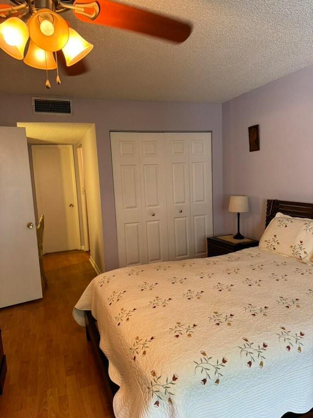 bedroom featuring a closet, ceiling fan, hardwood / wood-style flooring, and a textured ceiling