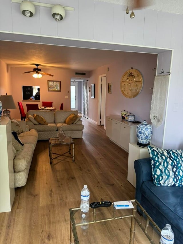 living room featuring ceiling fan and hardwood / wood-style flooring