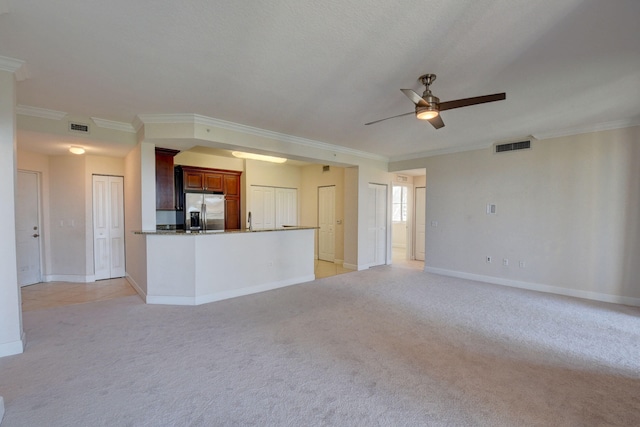 unfurnished living room featuring light colored carpet, ceiling fan, and ornamental molding