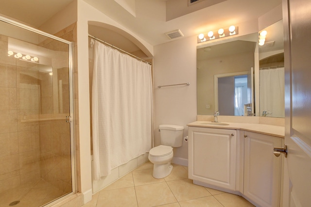 bathroom featuring tile patterned flooring, vanity, toilet, and walk in shower