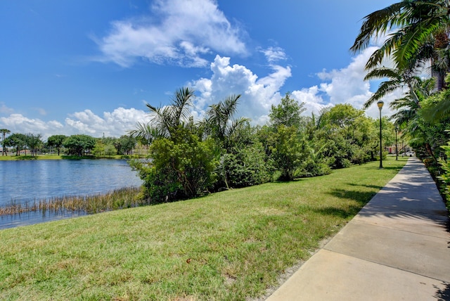 surrounding community featuring a lawn and a water view