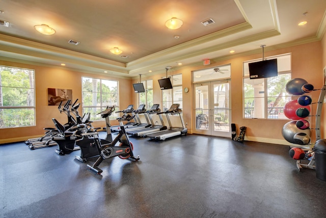 exercise room featuring ceiling fan, a raised ceiling, crown molding, and french doors