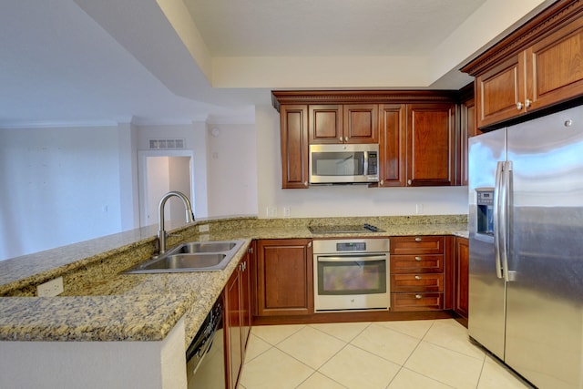 kitchen featuring light stone countertops, light tile patterned floors, stainless steel appliances, sink, and kitchen peninsula