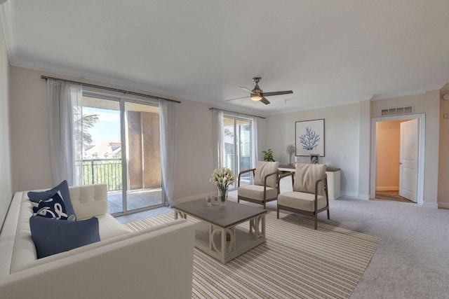 living room featuring crown molding, a healthy amount of sunlight, ceiling fan, and carpet floors