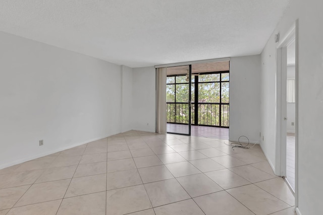 tiled spare room with a textured ceiling and floor to ceiling windows