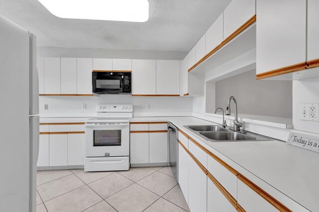 kitchen featuring white appliances, sink, white cabinets, and a textured ceiling