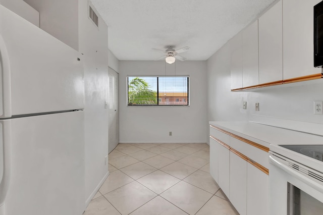 kitchen featuring white appliances, light tile patterned floors, white cabinetry, and ceiling fan