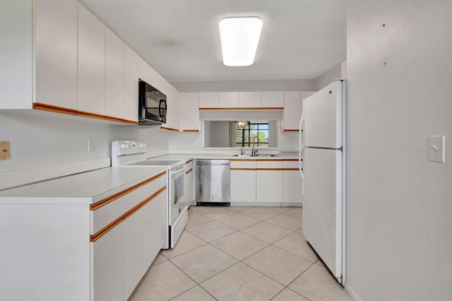 kitchen featuring white appliances, white cabinetry, sink, light tile patterned flooring, and a textured ceiling