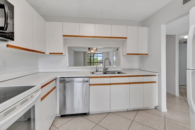 kitchen featuring white cabinets, dishwasher, light tile patterned floors, an inviting chandelier, and sink