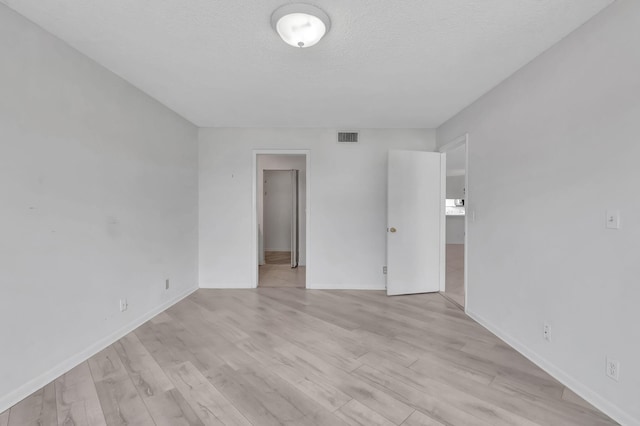 interior space with light wood-type flooring and a textured ceiling