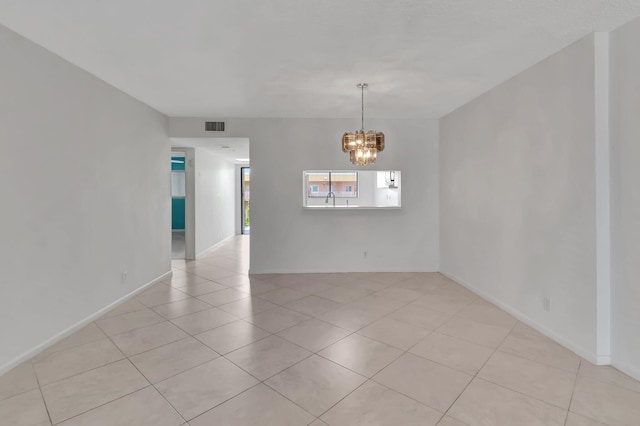 tiled empty room with a chandelier