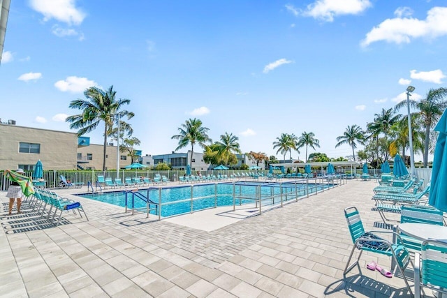 pool with a patio area and fence