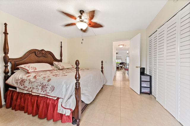 bedroom with a closet, light tile patterned floors, and ceiling fan