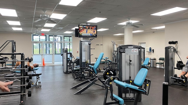 exercise room with a paneled ceiling and ceiling fan