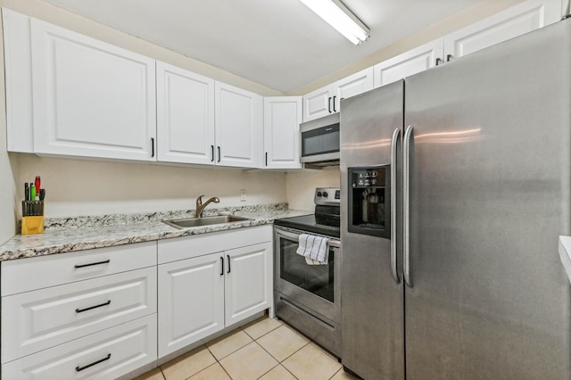 kitchen featuring white cabinets, stainless steel appliances, sink, and light tile patterned floors