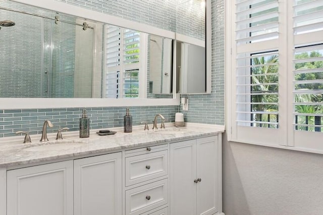 bathroom featuring vanity, tasteful backsplash, and a shower with door