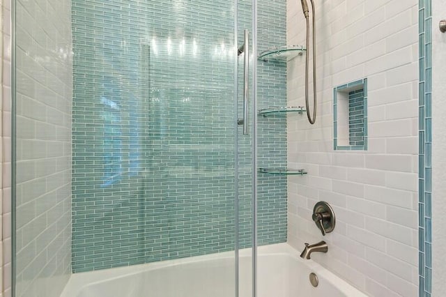 bathroom featuring combined bath / shower with glass door