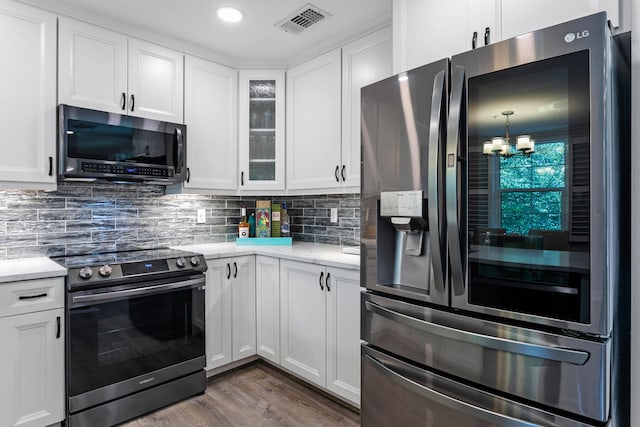 kitchen with a notable chandelier, white cabinetry, dark wood-type flooring, and appliances with stainless steel finishes