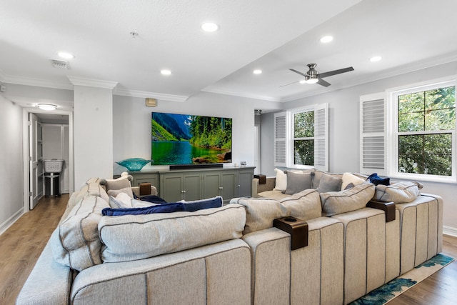 cinema room featuring hardwood / wood-style floors, ceiling fan, and ornamental molding