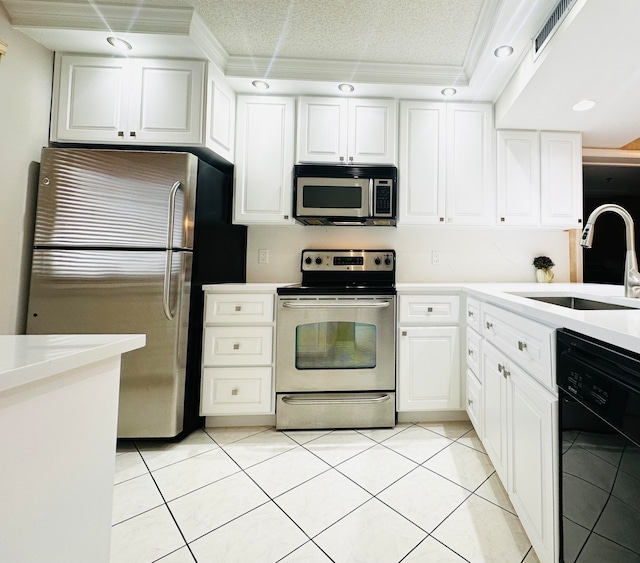 kitchen with stainless steel appliances, sink, light tile patterned floors, and white cabinetry