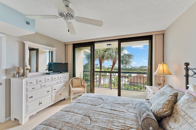 carpeted bedroom with a textured ceiling, expansive windows, access to exterior, and ceiling fan