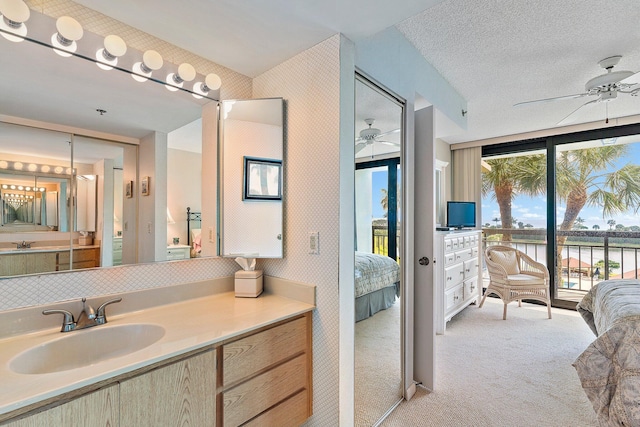 bathroom with a textured ceiling, vanity, and ceiling fan