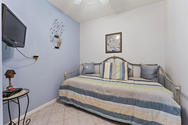 bedroom with a textured ceiling, light tile patterned flooring, and ceiling fan