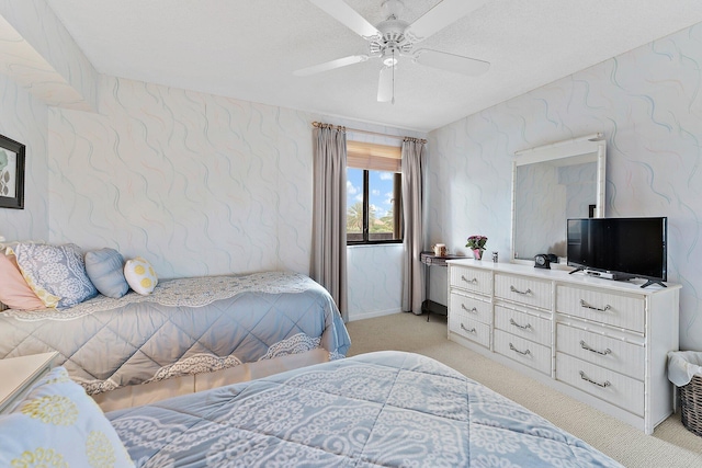 bedroom with a textured ceiling, ceiling fan, and light carpet