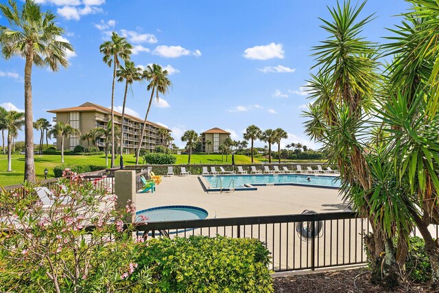 view of swimming pool with a community hot tub, a yard, and a patio area