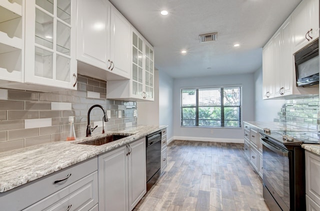 kitchen featuring white cabinets, sink, light hardwood / wood-style floors, and black appliances