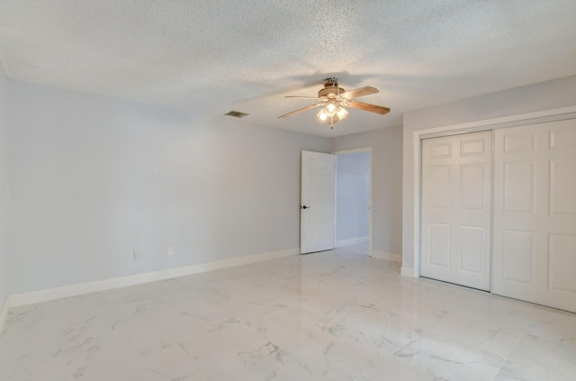 unfurnished bedroom with ceiling fan, a closet, and a textured ceiling