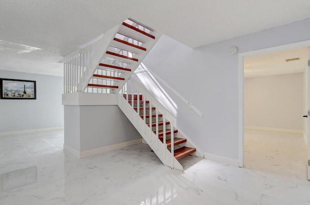 stairway with a textured ceiling