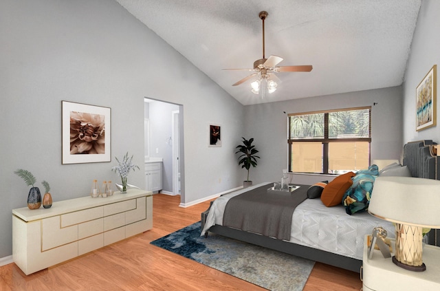 bedroom with connected bathroom, light hardwood / wood-style floors, ceiling fan, and lofted ceiling