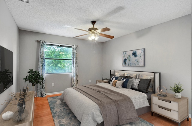 bedroom featuring a textured ceiling, hardwood / wood-style flooring, and ceiling fan