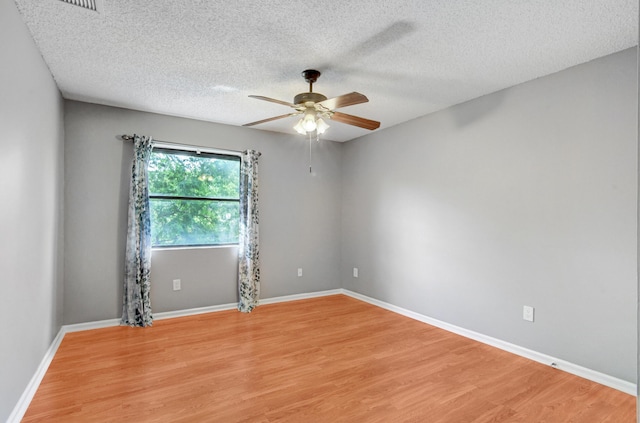 unfurnished room featuring a textured ceiling, light wood-type flooring, and ceiling fan