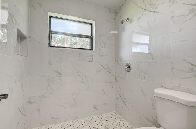 bathroom featuring toilet and a tile shower