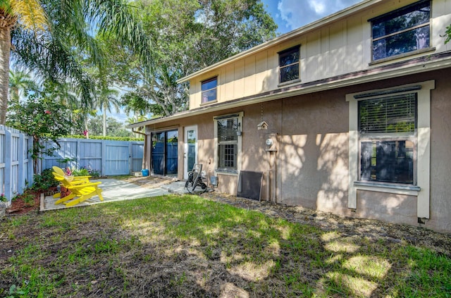 rear view of property featuring a lawn