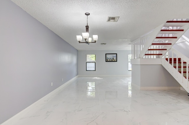 interior space with a notable chandelier and a textured ceiling