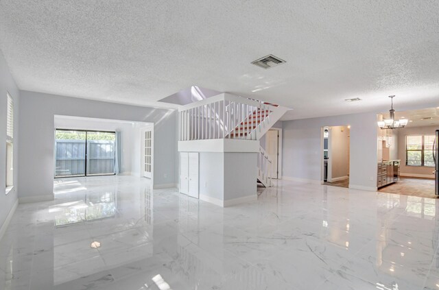 unfurnished living room with an inviting chandelier