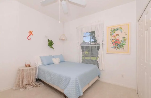 bedroom featuring a ceiling fan, a closet, and light colored carpet