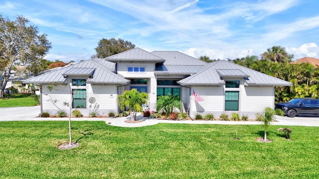 view of front of home with a standing seam roof, metal roof, and a front yard