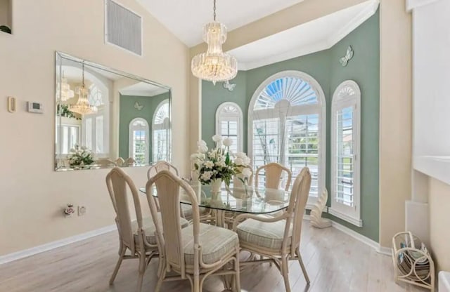 dining room featuring light wood-type flooring, baseboards, visible vents, and a chandelier